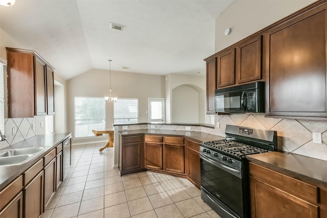 2212 Highland Crossing Dr, Conroe, TX 77304 - kitchen with gas range, black microwave, a sink, arched walkways, and decorative backsplash