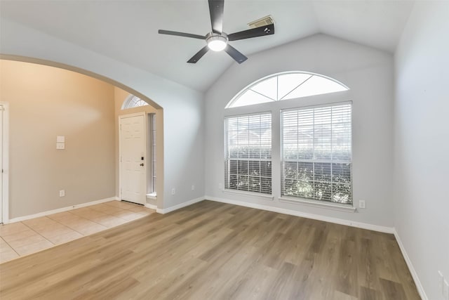 2212 Highland Crossing Dr, Conroe, TX 77304 - empty room with arched walkways, light wood finished floors, vaulted ceiling, ceiling fan, and baseboards