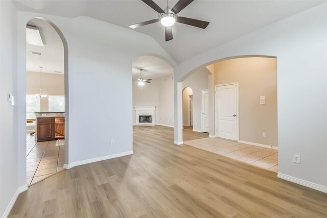 2212 Highland Crossing Dr, Conroe, TX 77304 - empty room featuring ceiling fan, light wood-style floors, lofted ceiling, a fireplace, and baseboards
