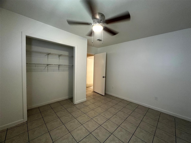 1023 W Snyder St, Alvin, TX 77511 - unfurnished bedroom with a closet, light tile patterned floors, a ceiling fan, and baseboards