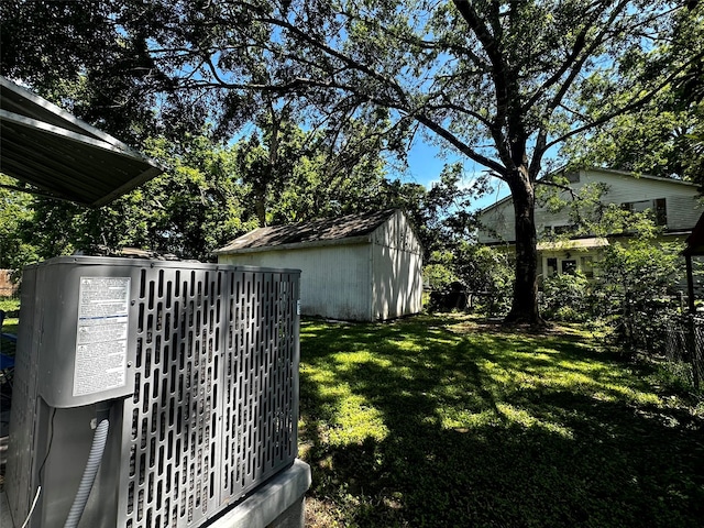 1023 W Snyder St, Alvin, TX 77511 - view of green lawn featuring central air condition unit, a storage unit, and an outbuilding
