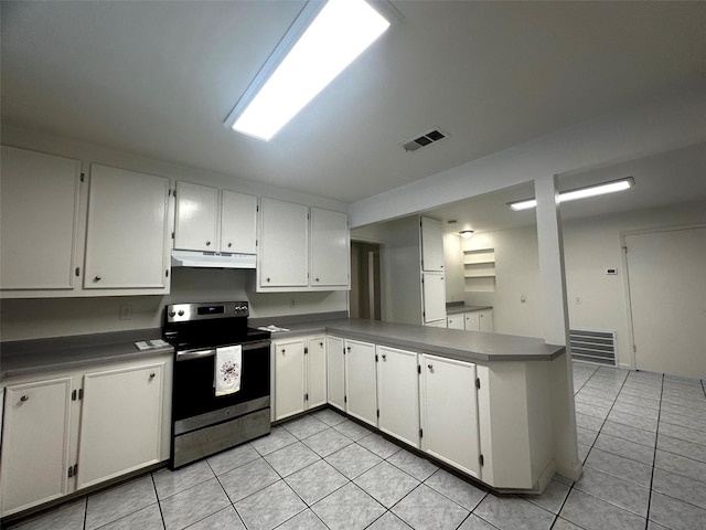 1023 W Snyder St, Alvin, TX 77511 - kitchen with stainless steel electric range oven, under cabinet range hood, light tile patterned floors, white cabinetry, and a peninsula
