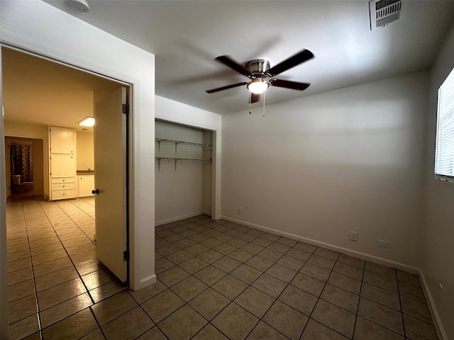 1023 W Snyder St, Alvin, TX 77511 - unfurnished bedroom with tile patterned flooring, a closet, baseboards, and a ceiling fan