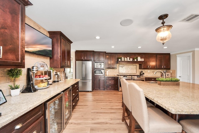 9731 Hadden Rd, Baytown, TX 77521 - kitchen with appliances with stainless steel finishes, beverage cooler, a sink, light wood-style floors, and decorative backsplash