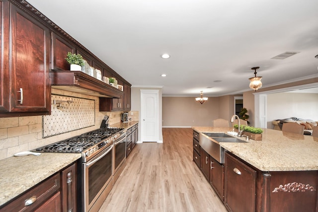 9731 Hadden Rd, Baytown, TX 77521 - kitchen featuring a sink, gas range, baseboards, tasteful backsplash, and light wood finished floors