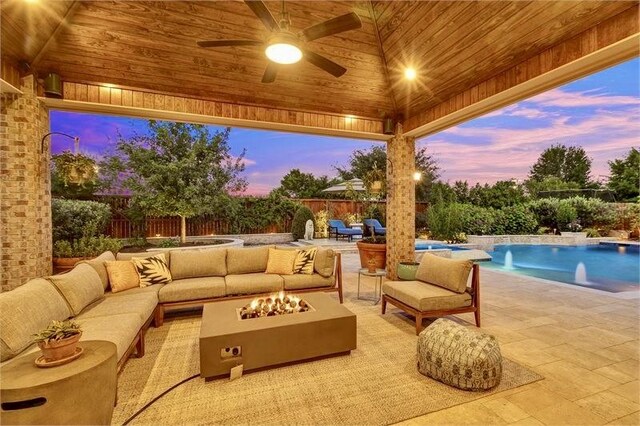 10210 Grape Creek Grove Ln, Cypress, TX 77433 - patio terrace at dusk with an outdoor living space with a fire pit, a patio area, a fenced backyard, and a ceiling fan