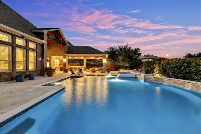 10210 Grape Creek Grove Ln, Cypress, TX 77433 - pool at dusk featuring a patio, an outdoor bar, and a pool with connected hot tub