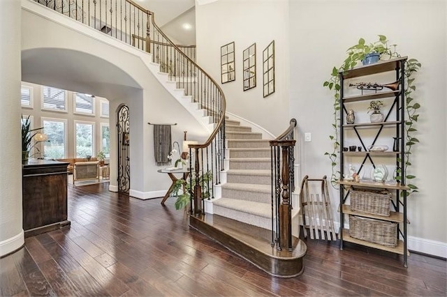 10210 Grape Creek Grove Ln, Cypress, TX 77433 - foyer with arched walkways, a towering ceiling, baseboards, and hardwood / wood-style flooring