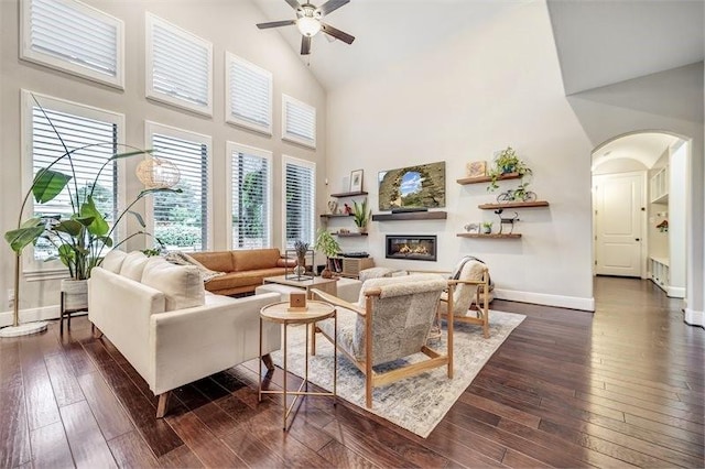10210 Grape Creek Grove Ln, Cypress, TX 77433 - living room featuring arched walkways, high vaulted ceiling, baseboards, ceiling fan, and a glass covered fireplace