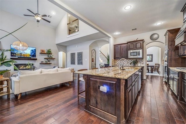 10210 Grape Creek Grove Ln, Cypress, TX 77433 - kitchen with arched walkways, appliances with stainless steel finishes, a sink, open floor plan, and a ceiling fan