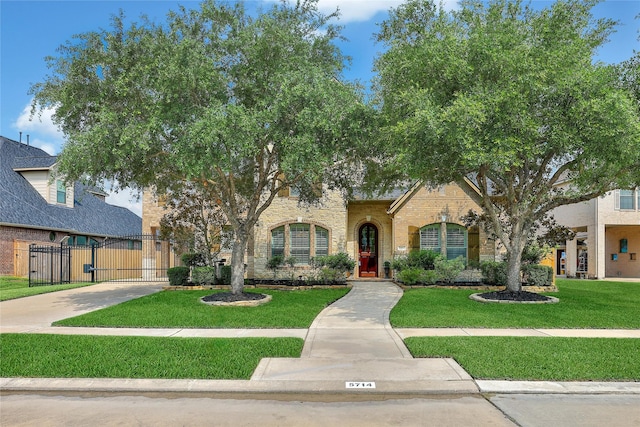 5714 Spring River Ln, Fulshear, TX 77441 - view of front facade featuring a gate, a front yard, stone siding, driveway, and brick siding