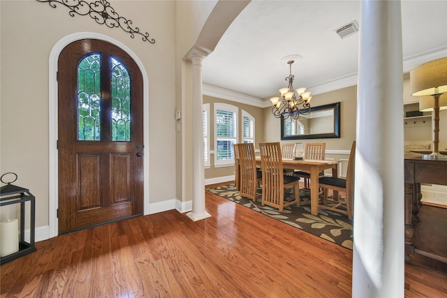 5714 Spring River Ln, Fulshear, TX 77441 - entryway with a chandelier, arched walkways, ornamental molding, wood finished floors, and ornate columns