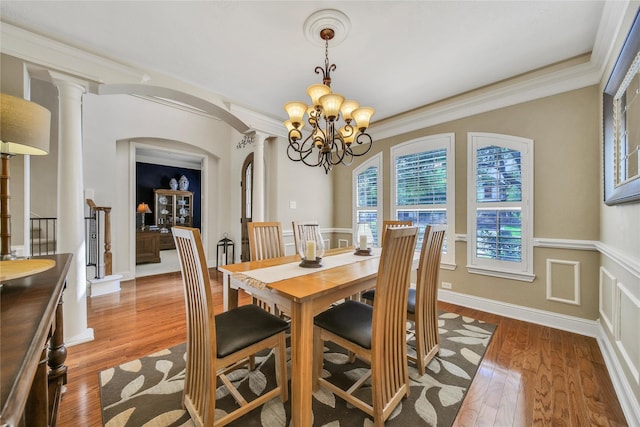 5714 Spring River Ln, Fulshear, TX 77441 - dining space featuring a chandelier, light wood-style floors, arched walkways, crown molding, and decorative columns