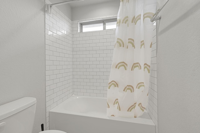 full bathroom featuring toilet, shower / bath combo, and a textured wall