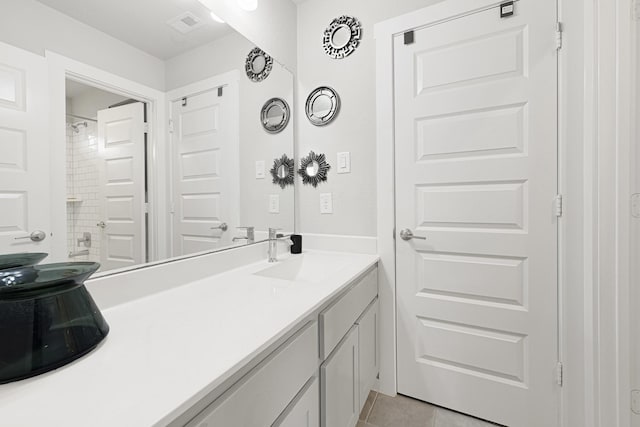 bathroom featuring vanity, tile patterned flooring, and a shower