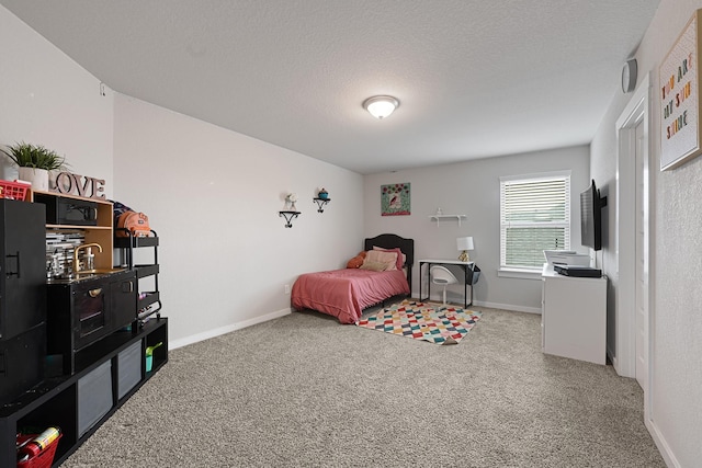 bedroom featuring carpet floors, baseboards, and a textured ceiling