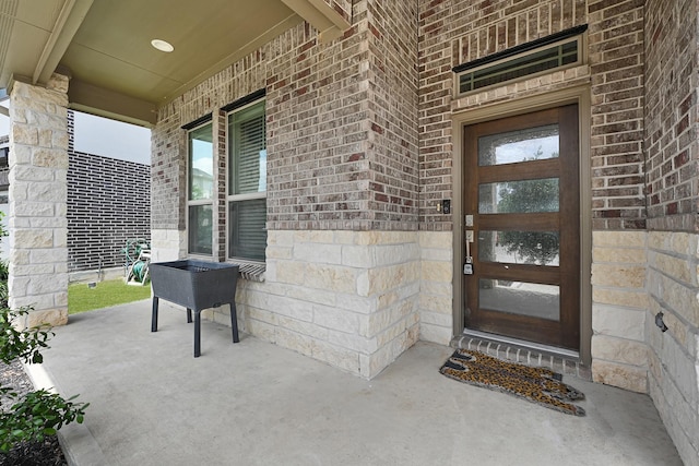 property entrance with brick siding and covered porch