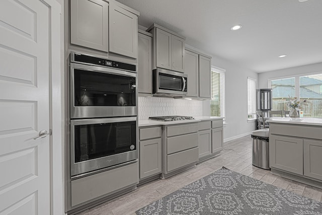 kitchen with gray cabinetry, appliances with stainless steel finishes, recessed lighting, and wood tiled floors