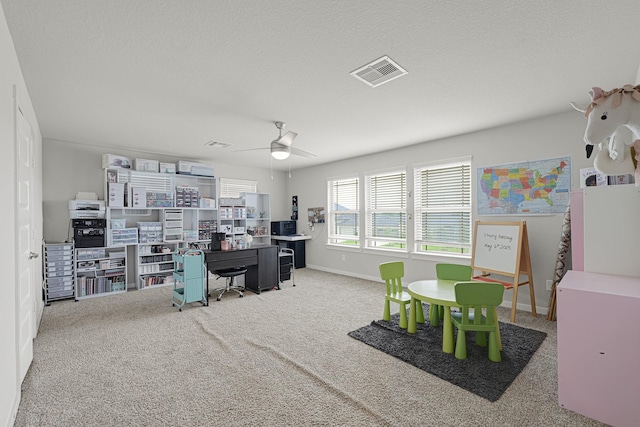 carpeted home office with ceiling fan and baseboards