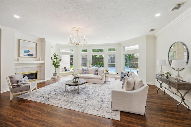 1602 Kelliwood Oaks Dr, Katy, TX 77450 - living area with crown molding, a textured ceiling, a chandelier, wood finished floors, and a tiled fireplace
