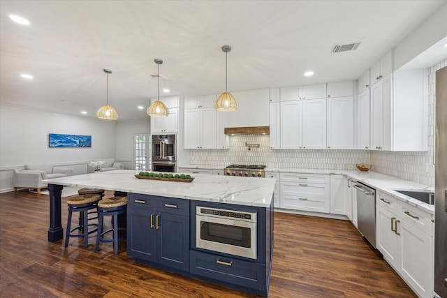 1602 Kelliwood Oaks Dr, Katy, TX 77450 - kitchen featuring stainless steel appliances, white cabinetry, blue cabinets, dark wood-style flooring, and recessed lighting