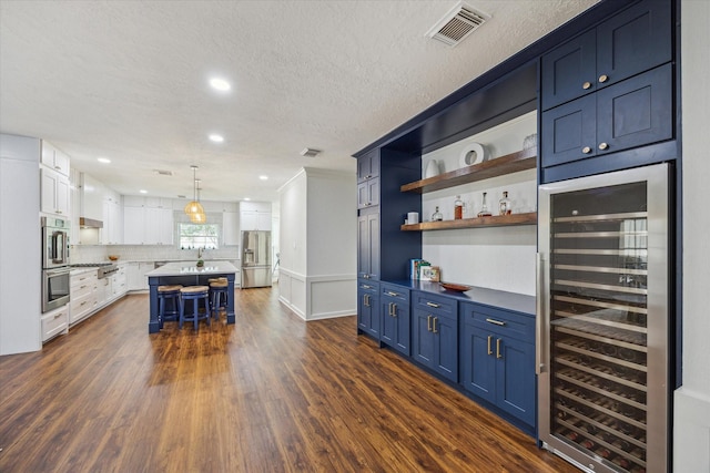 1602 Kelliwood Oaks Dr, Katy, TX 77450 - bar area featuring beverage cooler, stainless steel appliances, dark wood finished floors, tasteful backsplash, and recessed lighting