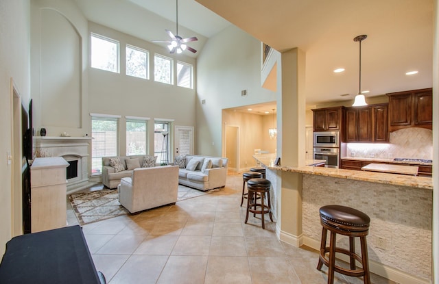 3539 Vasser Ridge Dr, Spring, TX 77388 - kitchen with appliances with stainless steel finishes, a kitchen breakfast bar, light stone countertops, a high ceiling, and ceiling fan