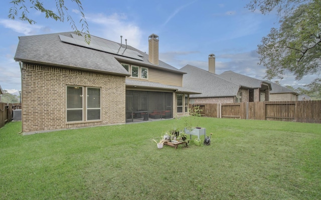 3539 Vasser Ridge Dr, Spring, TX 77388 - rear view of house with brick siding, roof mounted solar panels, a shingled roof, a sunroom, and a chimney