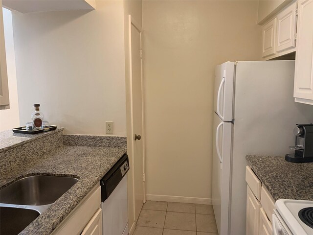10075 Westpark Dr Unit 43, Houston, TX 77042 - kitchen with white appliances, light tile patterned flooring, a sink, white cabinetry, and dark stone counters
