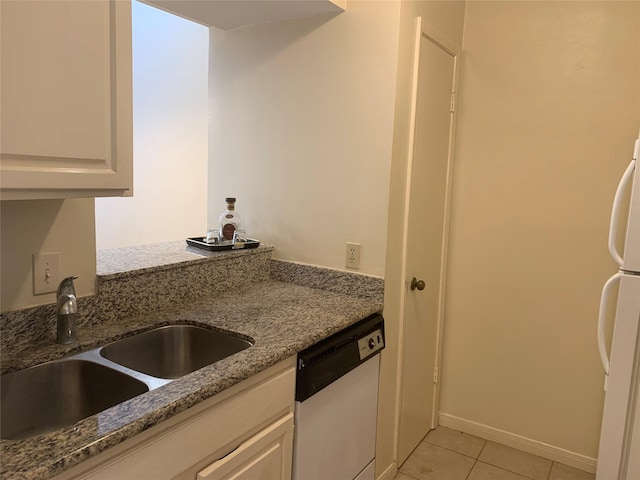 10075 Westpark Dr Unit 43, Houston, TX 77042 - kitchen with white appliances, a sink, light tile patterned flooring, stone counters, and white cabinets