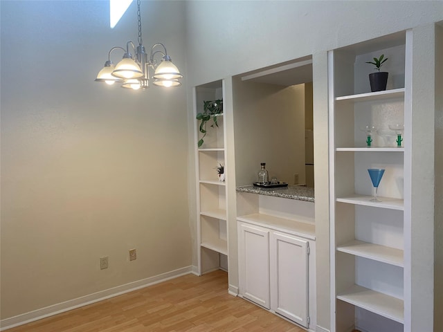 10075 Westpark Dr Unit 43, Houston, TX 77042 - unfurnished dining area with light wood-style floors, a chandelier, and baseboards
