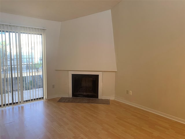 10075 Westpark Dr Unit 43, Houston, TX 77042 - unfurnished living room with light wood-style flooring, baseboards, and a fireplace with flush hearth