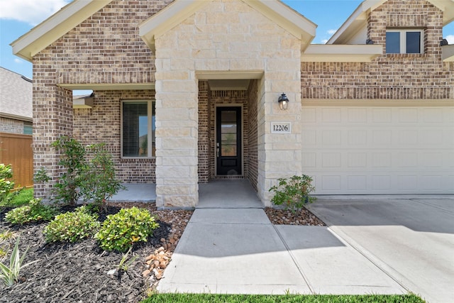 12206 English Mist Dr, Houston, TX 77044 - view of exterior entry with an attached garage, driveway, and brick siding