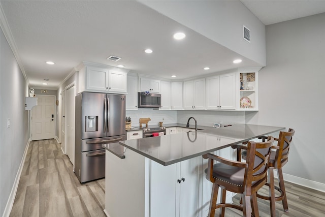 801 River Rd Unit E-102, Montgomery, TX 77356 - kitchen with stainless steel appliances, light wood-style flooring, baseboards, a peninsula, and recessed lighting