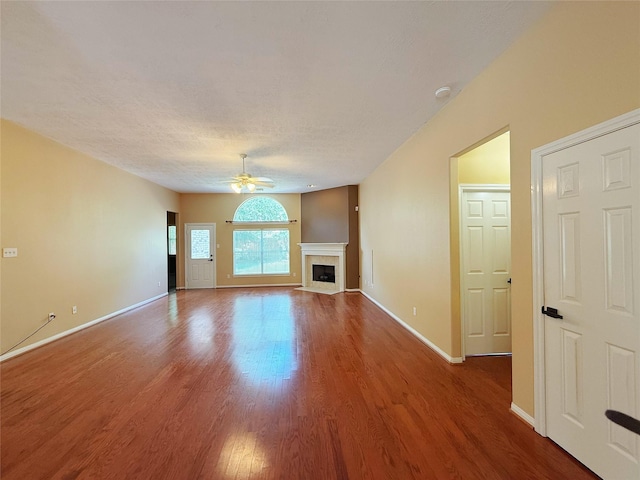 16322 E Amber Willow Trl, Cypress, TX 77433 - unfurnished living room with a ceiling fan, wood finished floors, a fireplace with flush hearth, and baseboards