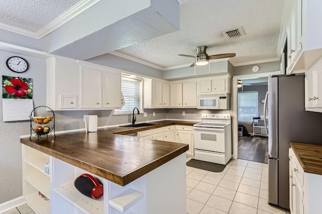 15335 Poplar Grove Dr, Houston, TX 77068 - kitchen with white appliances, a sink, wood counters, a textured ceiling, and a peninsula