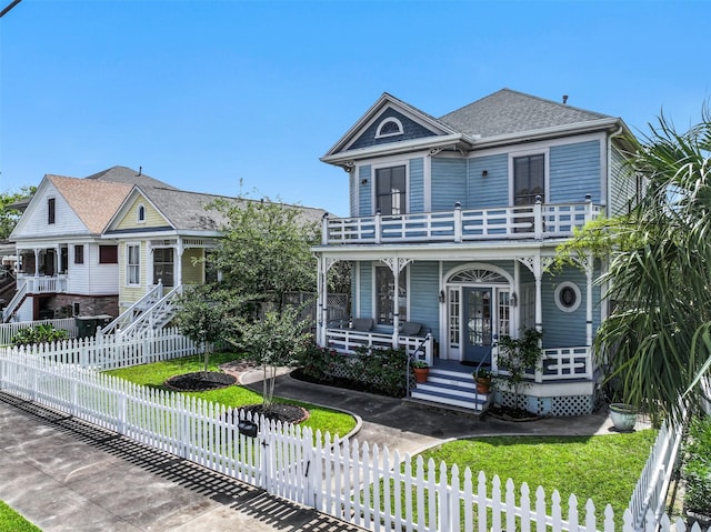 1515 24th St, Galveston, TX 77550 - victorian house with a balcony, a porch, stairs, and roof with shingles