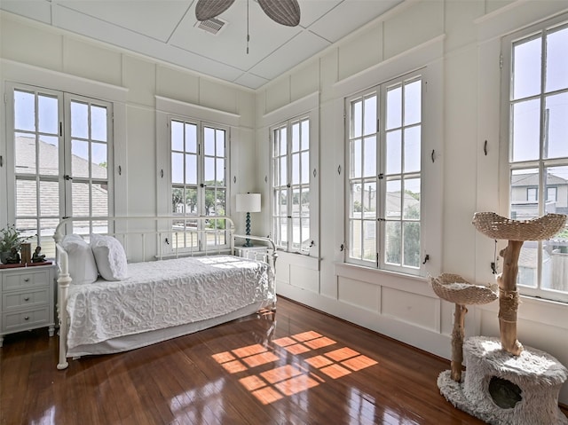 1515 24th St, Galveston, TX 77550 - bedroom with a decorative wall, access to outside, dark wood-style flooring, multiple windows, and ceiling fan