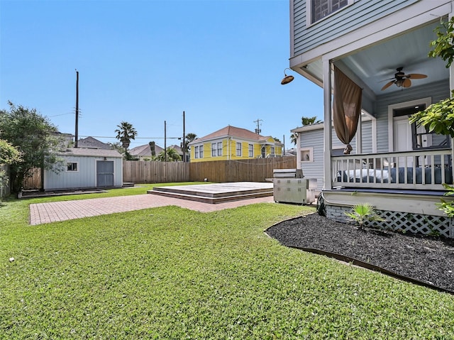 1515 24th St, Galveston, TX 77550 - view of yard with ceiling fan, a wooden deck, an outbuilding, and a patio