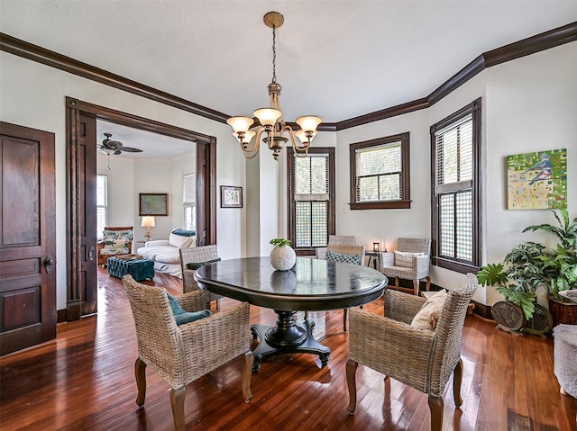 1515 24th St, Galveston, TX 77550 - dining room featuring crown molding, a chandelier, dark wood-style floors, and baseboards