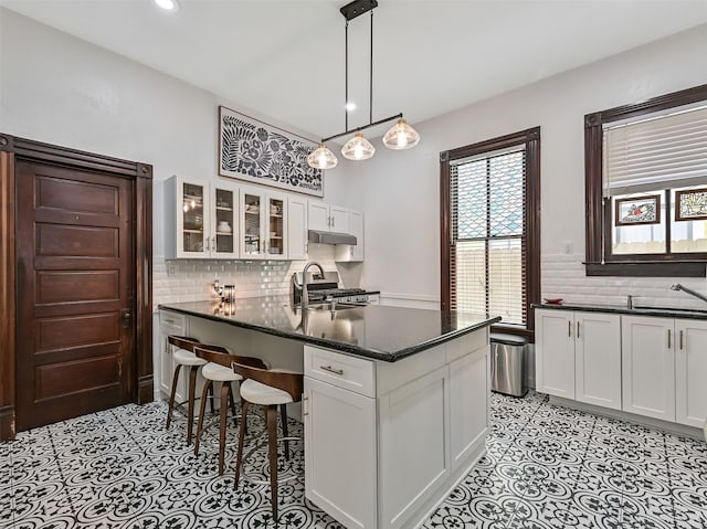 1515 24th St, Galveston, TX 77550 - kitchen with a sink, white cabinetry, glass insert cabinets, tasteful backsplash, and recessed lighting