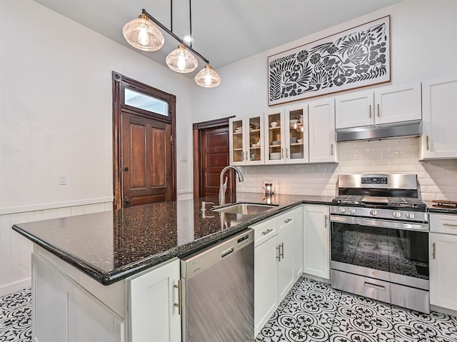 1515 24th St, Galveston, TX 77550 - kitchen featuring appliances with stainless steel finishes, under cabinet range hood, a sink, white cabinetry, and a peninsula