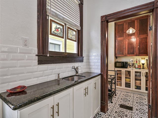 1515 24th St, Galveston, TX 77550 - kitchen with a sink, black microwave, tasteful backsplash, dark stone countertops, and white cabinets