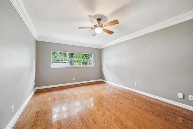 empty room featuring wood finished floors, ceiling fan, crown molding, a textured ceiling, and baseboards