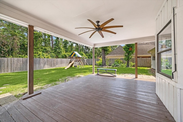wooden deck with a playground and a ceiling fan