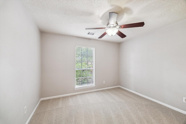 carpeted spare room with ceiling fan, a textured ceiling, and baseboards