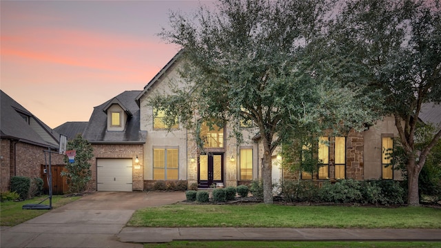 17803 Paint Bluff Ln, Cypress, TX 77433 - french country style house featuring concrete driveway, brick siding, a garage, and stone siding