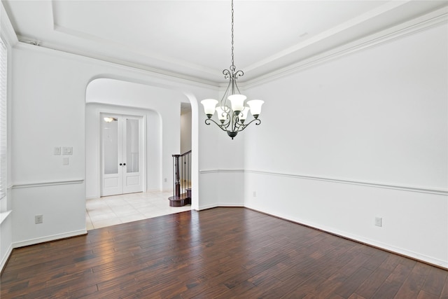 17803 Paint Bluff Ln, Cypress, TX 77433 - unfurnished room with wood finished floors, a raised ceiling, arched walkways, and a chandelier