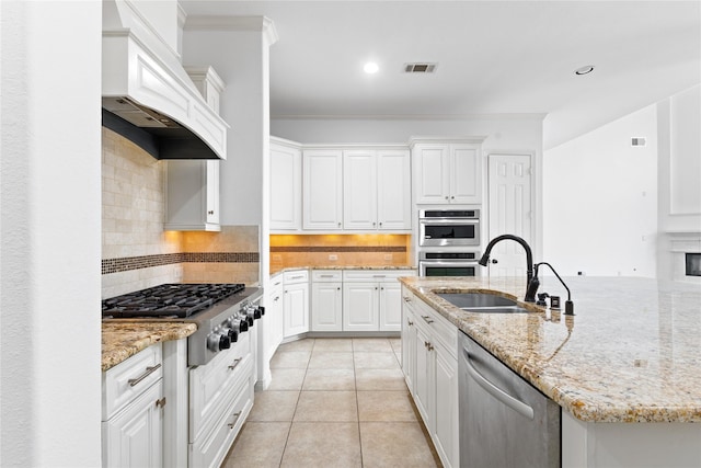 17803 Paint Bluff Ln, Cypress, TX 77433 - kitchen with a sink, stainless steel appliances, premium range hood, ornamental molding, and white cabinets