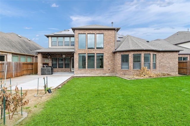 17803 Paint Bluff Ln, Cypress, TX 77433 - rear view of house featuring brick siding, a patio, solar panels, and roof with shingles